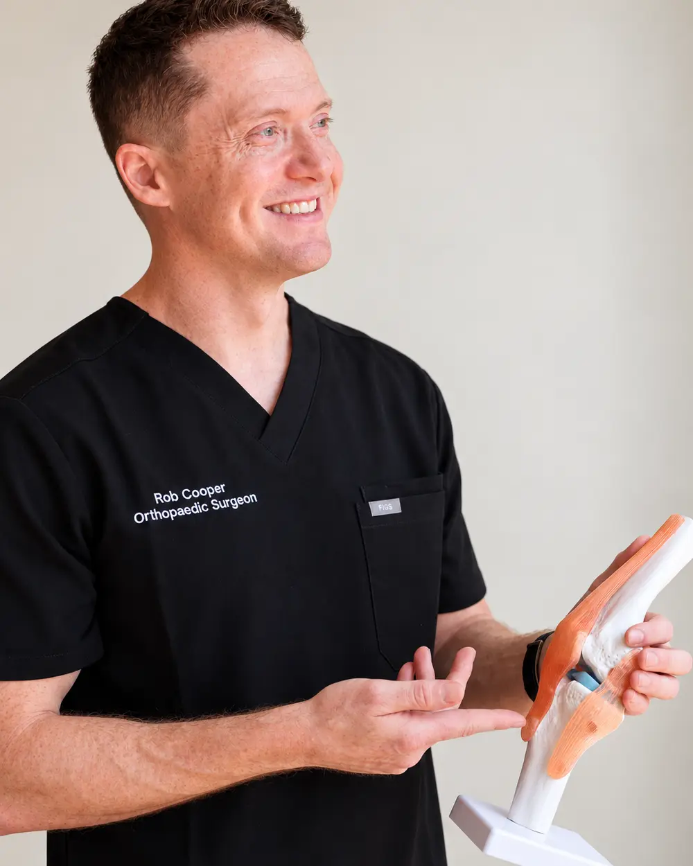 Dr Rob Cooper in his consulting rooms, explaining a knee model